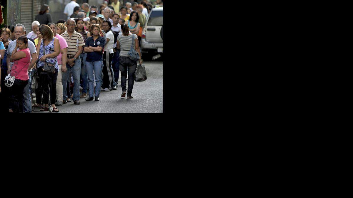 
Un grupo de personas hace fila para comprar en una tienda de Caracas, en esta fotografía de archivo.