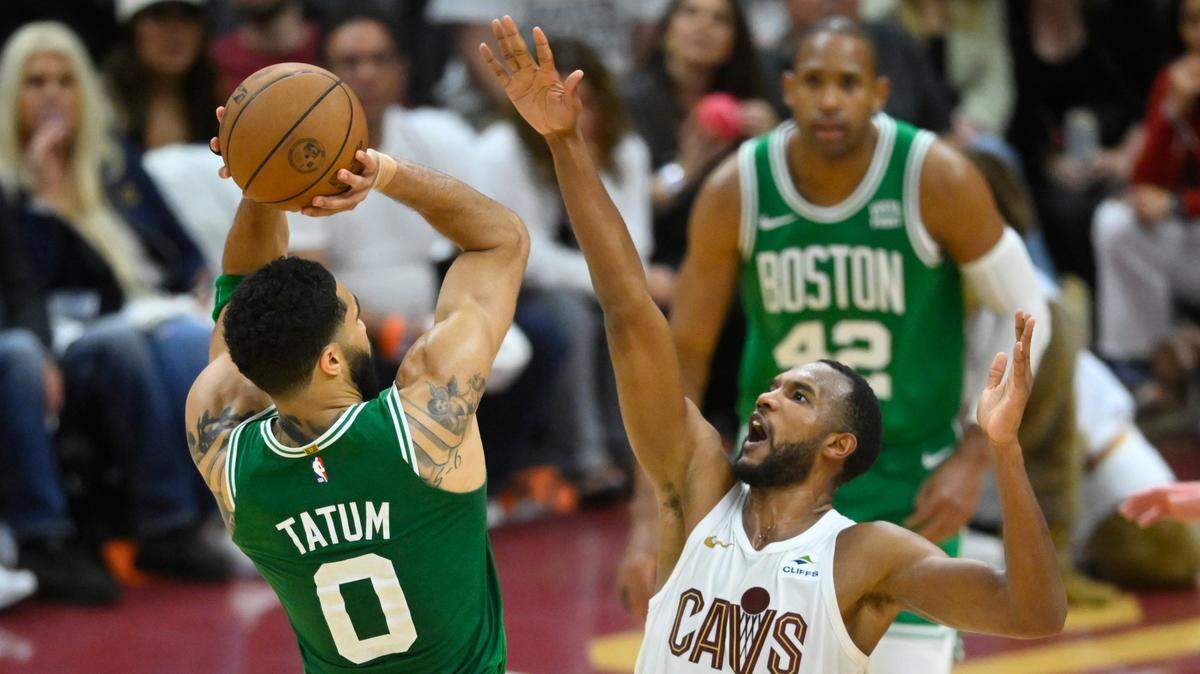 El jugador de los Celtics de Boston Jayson Tatum (0) tira al aro ante la marca de Evan Mobley, de los Cavaliers, en el cuarto partido del playoff semifinal de la Conferencia Este, celebrado el 13 de mayo de 2024 en Cleveland.