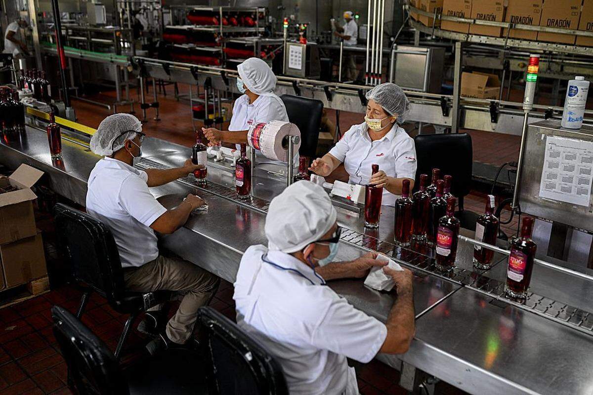 Empleados colocan etiquetas en botellas en la fábrica de ron Santa Teresa en La Victoria, estado Aragua, Venezuela, el 17 de diciembre de 2025. 