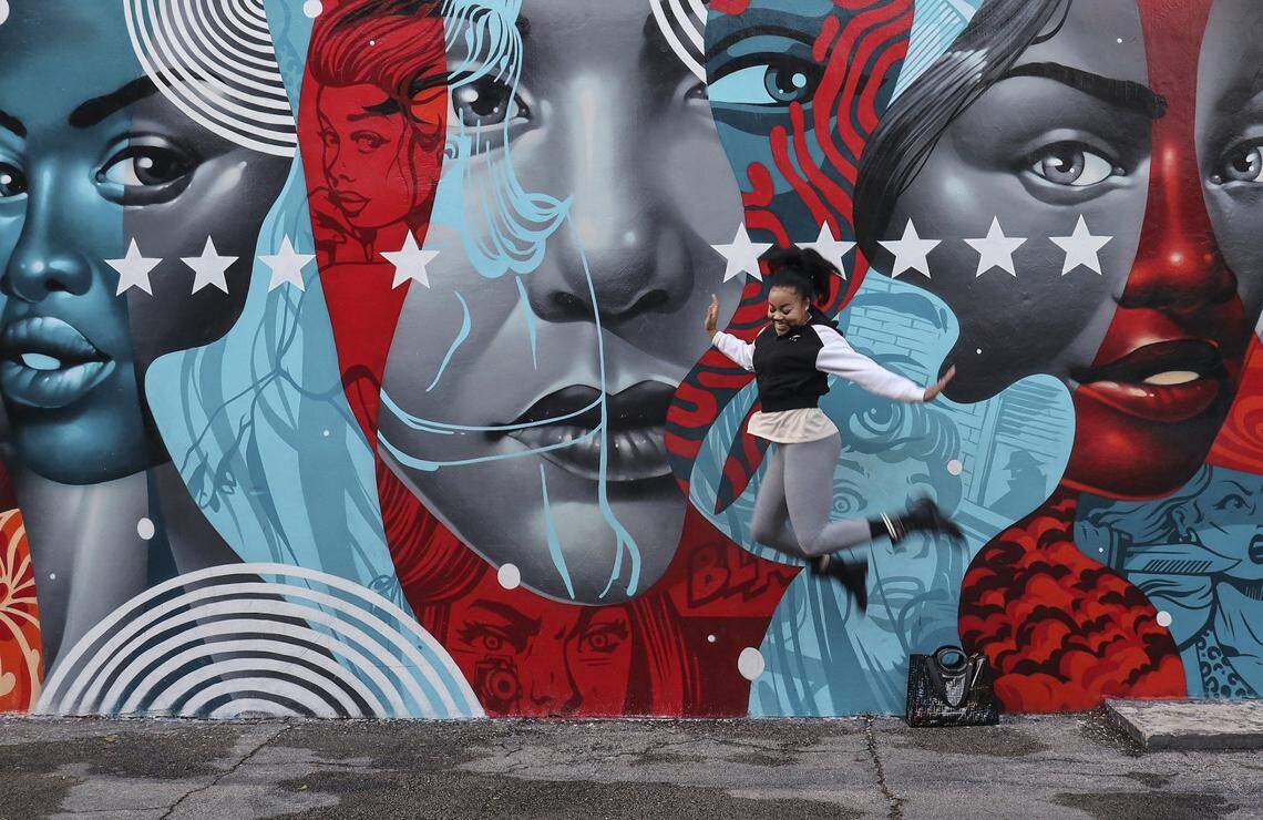 Tia Williams, who is visiting from Memphis, TN leaps in the air while a friend takes a quick photo inside Wynwood Walls where local, national, and international visitors visited the out door gallery of murals as Wynwood Walls will celebrate its 10th anniversary during Miami Art Basel on Sunday, November 25, 2019.