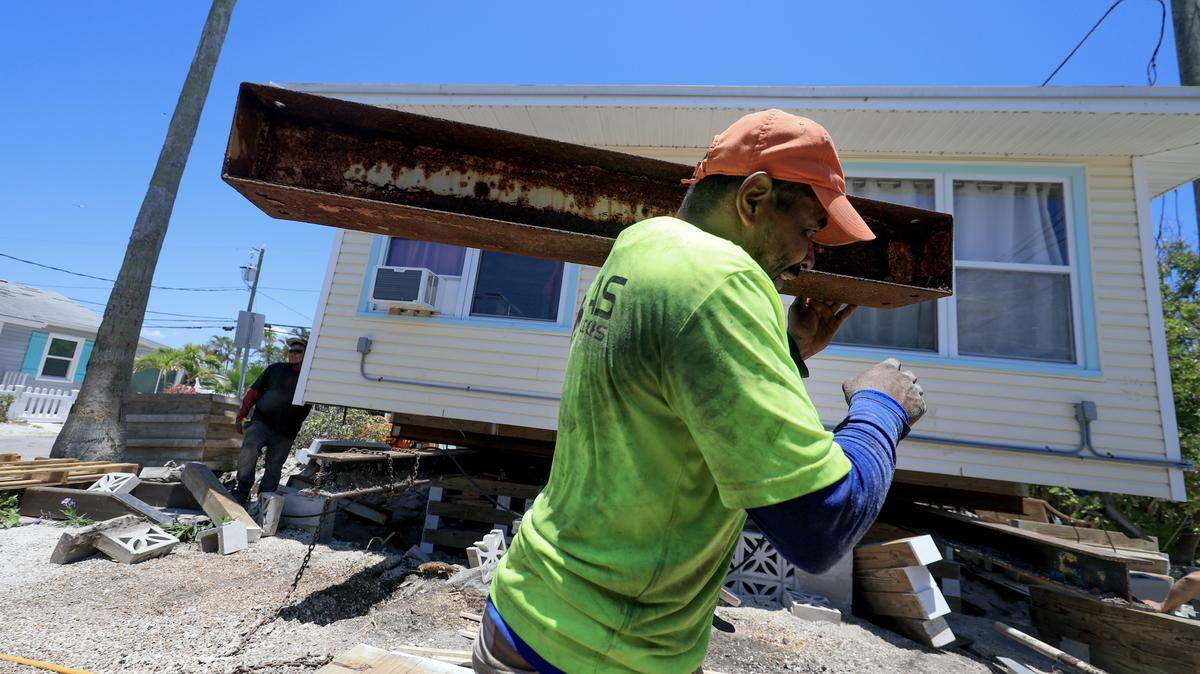 TREASURE ISLAND, FLORIDA - MAY 23: A worker with JAS Builders and Payne Construction Services helps raise a home with jacks and framing material on May 23, 2025 in Treasure Island, Florida. The companies are experiencing a surge in demand as homeowners hire them to elevate their homes in response to increasingly severe hurricanes, storm surges, and flooding caused by heavy rainfall. Currently, they are building 15 to 20 homes per month following the most recent hurricanes that struck the area. (Photo by Joe Raedle/Getty Images)