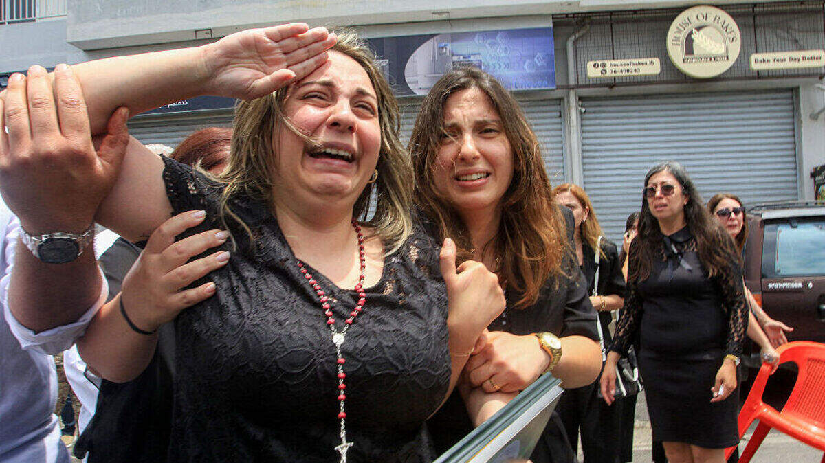 Rosette Tannous, esposa del capitán del ejército libanés Elie Khoury —fallecido a causa de un bombardeo israelí—, hace el saludo militar mientras los asistentes al funeral transportan el féretro de su marido en su pueblo natal de Kfar Jarra, cerca de Jezzine, en el sur del Líbano, el lunes 8 de junio de 2026.