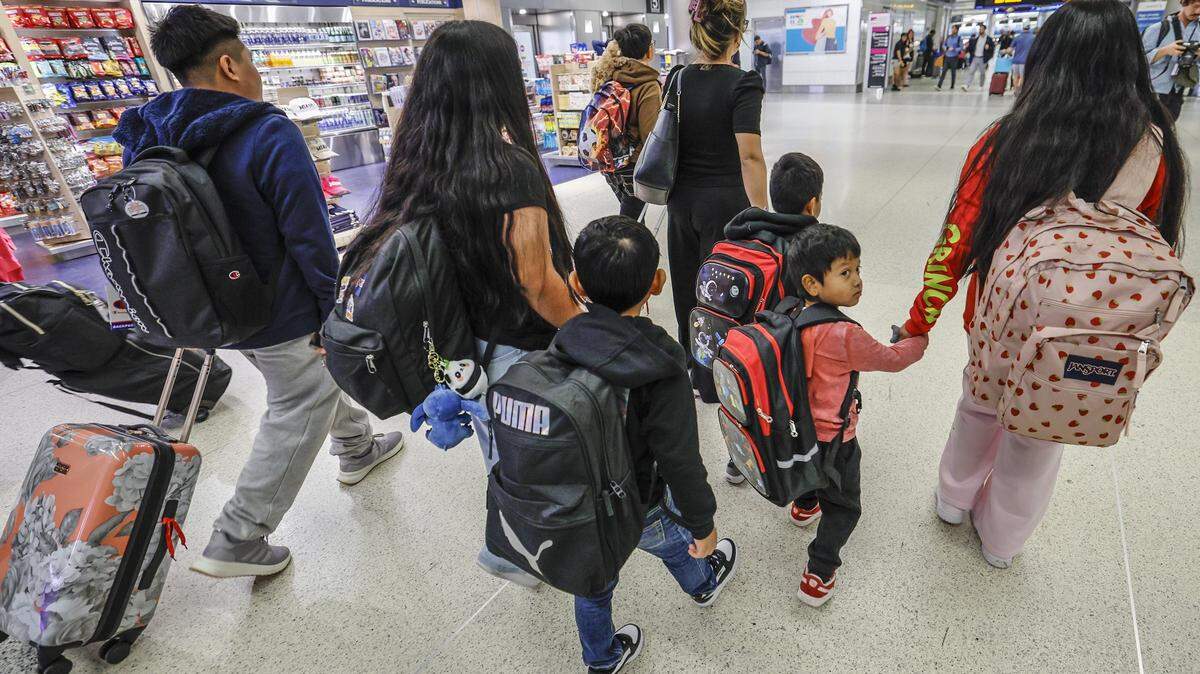 Luisa Gutiérrez, al frente, escolta a siete niños de seis familias que vuealn a Guatemala desde el Aeropuerto Internacional de Miami este jueves.