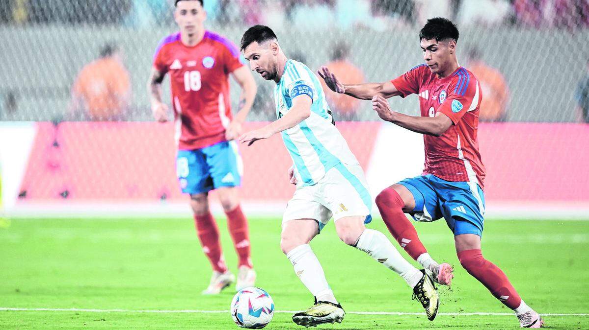 El astro de Argentina Lionel Messi (centro) trata de burlar la marca de Víctor Dávila, de Chile, en el partido de la Copa América celebrado el 25 de junio de 2024 en el MetLife Stadium en Nueva Jersey.
