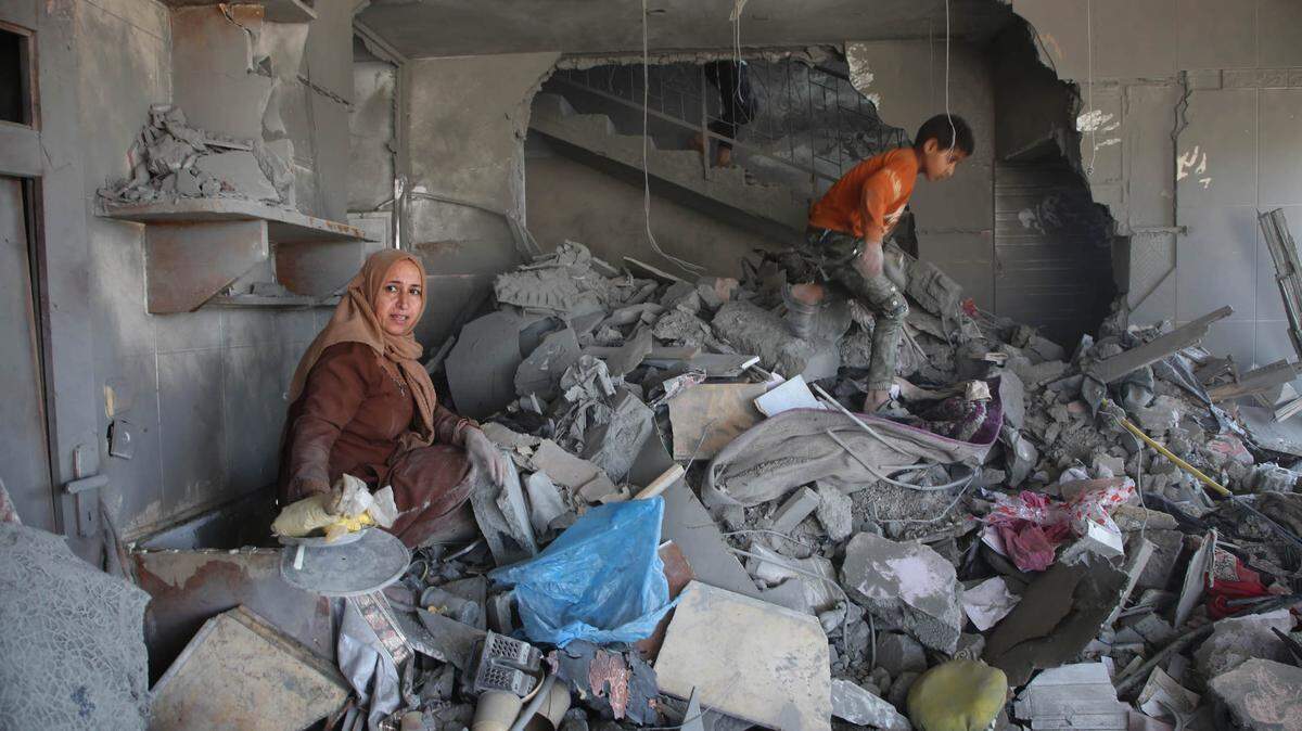 Una mujer y un niño revisan los restos de un edificio destruido en la ciudad de Rafah, en Gaza, el sabado 20 de abril de 2024.