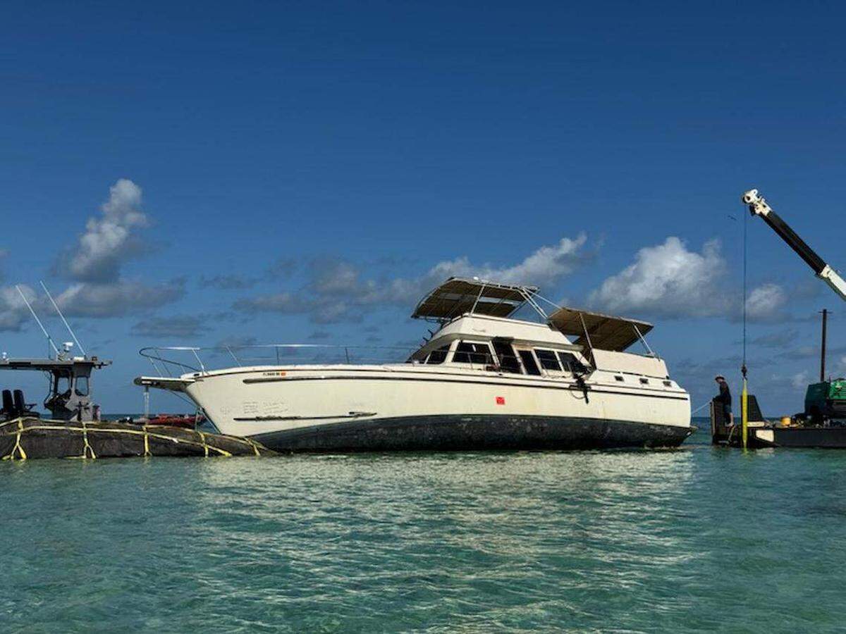 Equipos de trabajo retiran una lancha de recreo de 65 pies de eslora de Sisters Creek en Marathon, en la parte central de los Cayos de la Florida. Fue uno de los cientos de barcos abandonados retirados de las aguas del Condado Monroe en 2025.