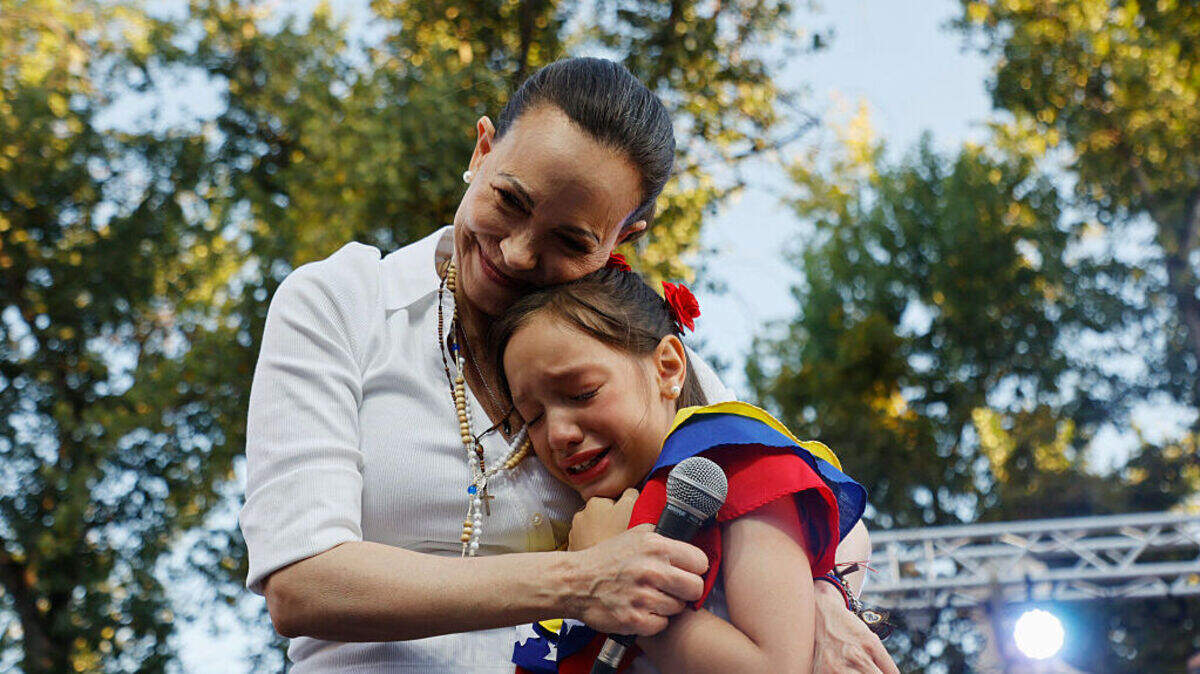 La líder opositora y Nobel de la Paz María Corina Machado abraza a una niña durante un encuentro con miembros de la comunidad venezolana en la Plaza Almagro de Santiago, Chile, el 12 de marzo de 2026.