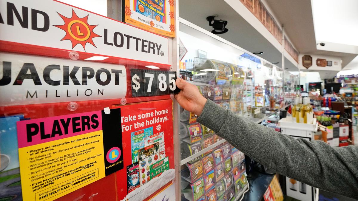 Un empleado de Broad Street Liquors actualiza el monto del premio mayor de Mega Millions en el mostrador de lotería de la tienda, el martes 3 de enero de 2023, en Timonium, Maryland