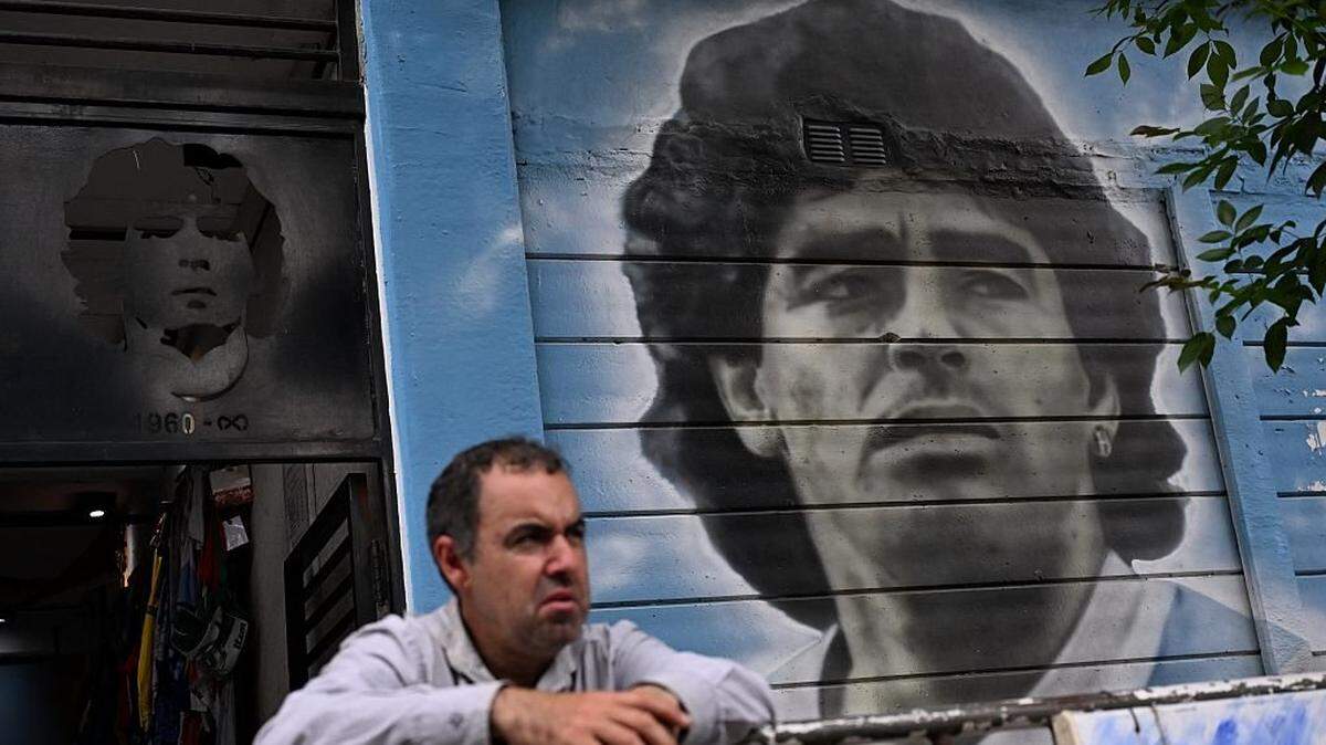 Un hombre posa junto a un mural con la figura de Diego Armando Maradona en el barrio de La Paternal, Buenos Aires, el 2 de diciembre de 2025. 
