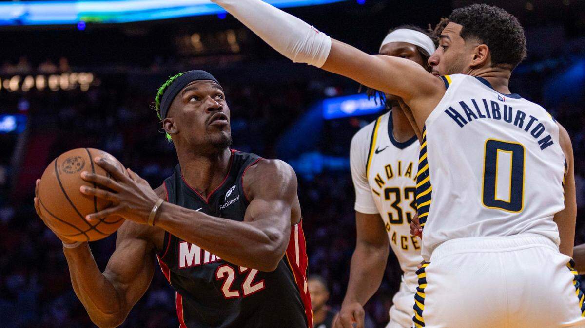 El delantero del Miami Heat, Jimmy Butler (22), se prepara para disparar alrededor del escolta de los Indiana Pacers, Tyrese Haliburton (0), durante la segunda mitad de un partido de la NBA en el Kaseya Center el jueves 2 de enero de 2025, en Miami, Florida.