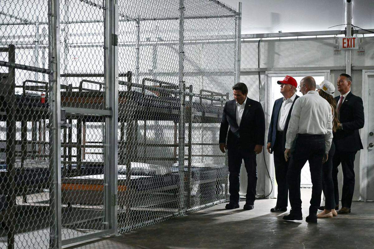 El presidente de los Estados Unidos, Donald Trump (2 de la izq.), junto con el gobernador de Florida, Ron DeSantis (izq), recorren el centro de detención de migrantes, denominado “Alligator Alcatraz”, ubicado en el sitio del Aeropuerto de Entrenamiento y Transición Dade-Collier en Ochopee, Florida, el 1 de julio de 2025.