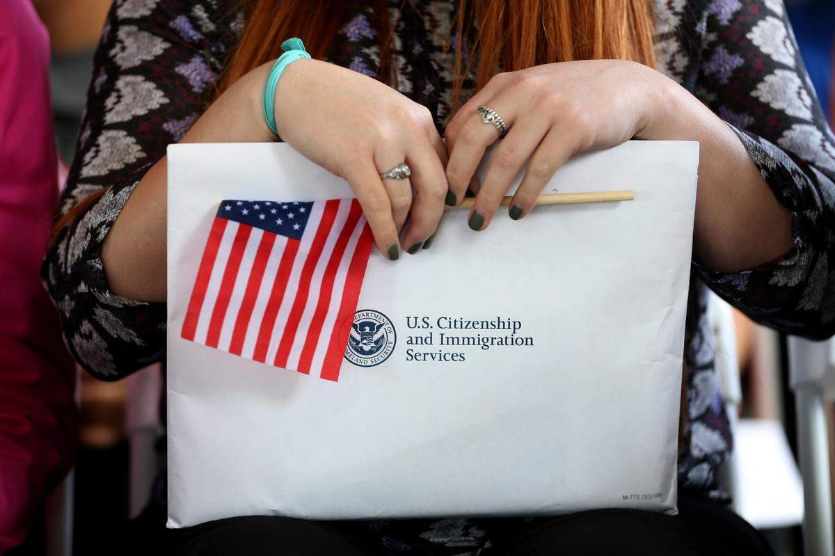 Una ciudadana estadounidense recién jurada retiene su documentación durante una ceremonia de naturalización organizada por el Servicio de Ciudadanía e Inmigración en el Parque Nacional Biscayne el 17 de febrero de 2015 en Homestead, Florida.