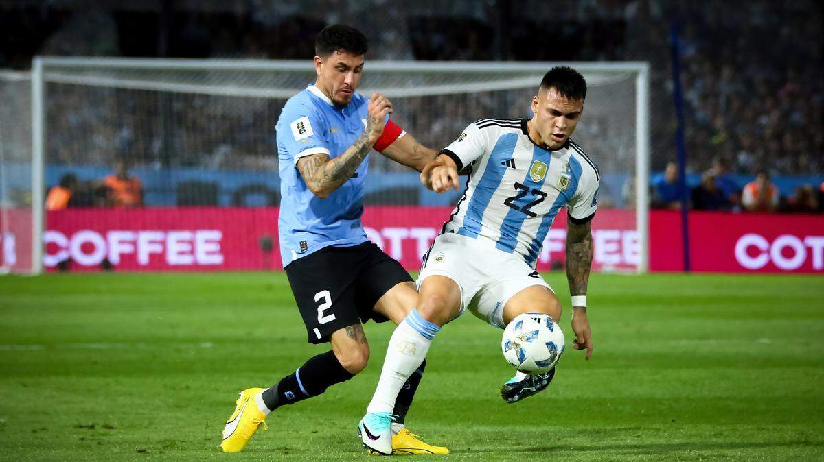 El jugador de Uruguay José María Giménez (izq.) lucha por la pelota con Lautaro Martínez, de Argentina, en el partido de la eliminatoria sudamericana celebrado el 16 de noviembre de 2023 en Buenos Aires.