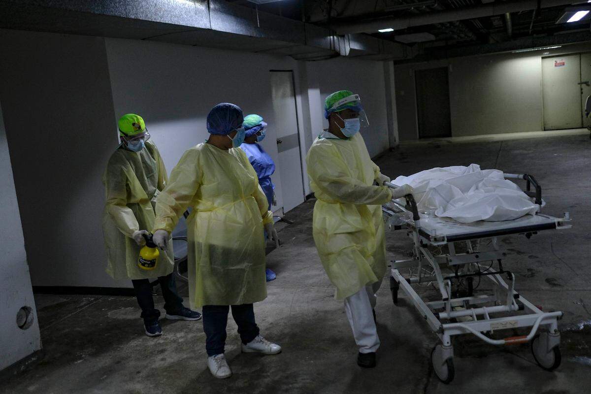 Jessi Durán watches as a health care worker pushes a stretcher with the body of his aunt, who died of COVID-19 at the Ana Francisca Pérez de León II Public Hospital en Caracas, Venezuela, on March 23, 2021.