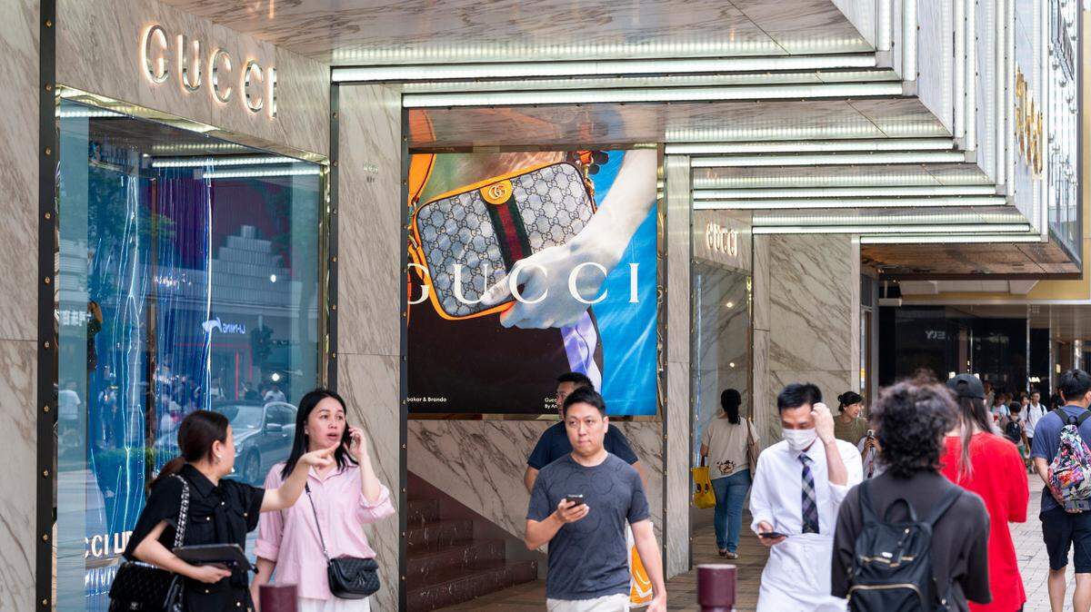 Foto de archivo de compradores caminando frente a la tienda de la marca de moda italiana Gucci, en un centro comercial en Pekín, el 14 de abril de 2025.