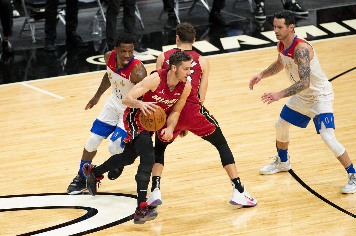 New Orleans Pelicans guard Eric Bledsoe (6) defends as Miami Heat guard Goran Dragic (7) drives to the basket around a screen by teammate Duncan Robinson (55) in the first quarter of a NBA basketball game on Christmas Day at the AmericanAirlines Arena on Friday, December 25, 2020.