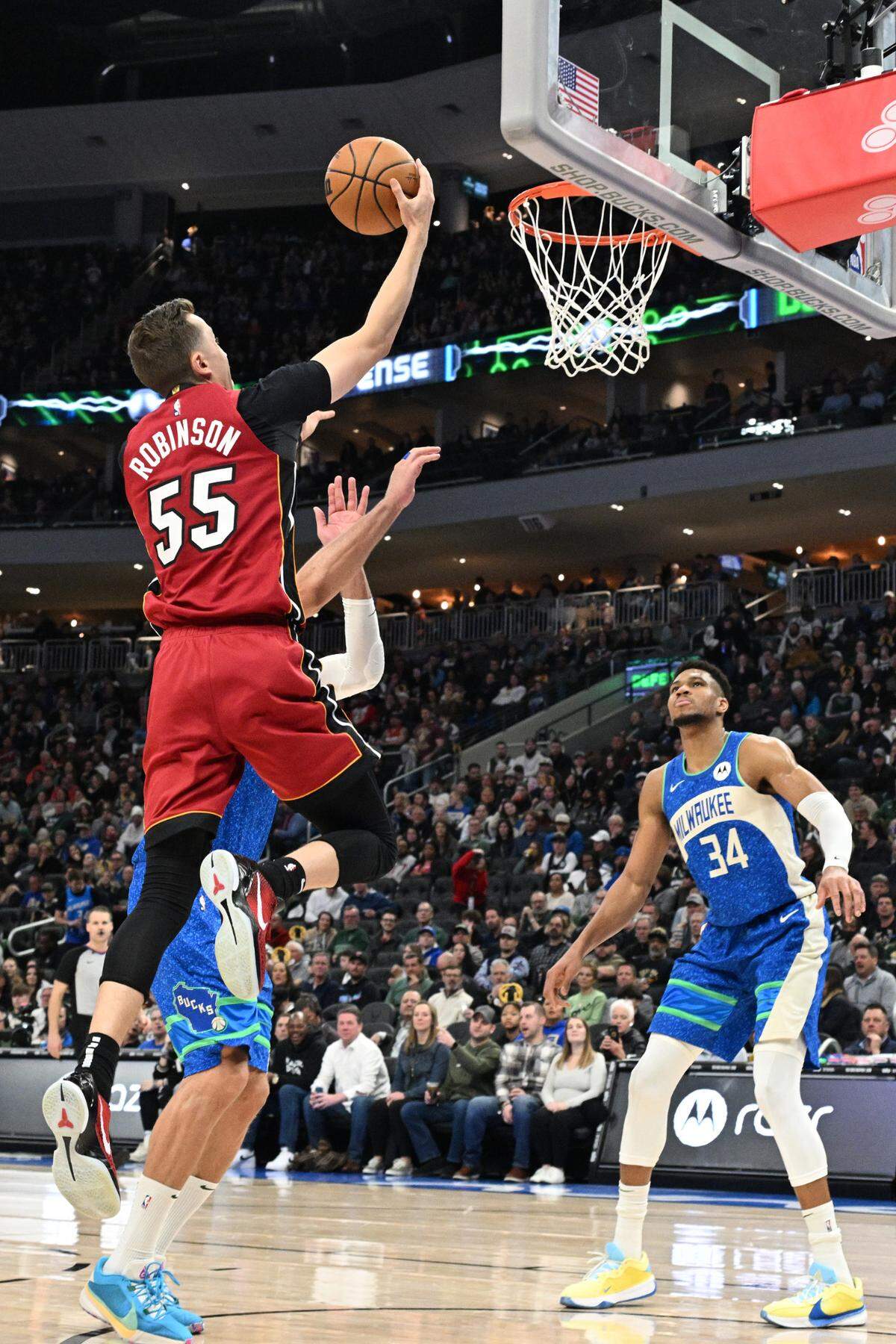 El jugador del Heat de Miami Duncan Robinson (55) entra al aro ante la marca de Brook López (11), de los Bucks de Milwaukee, en el partido celebrado el 13 de febrero de 2024 en Milwaukee.