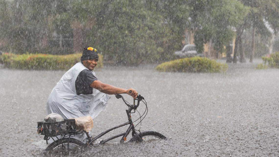 A resident tried to cycle on a flooded street in Fort Lauderdale on April 13 after a torrential downpour.