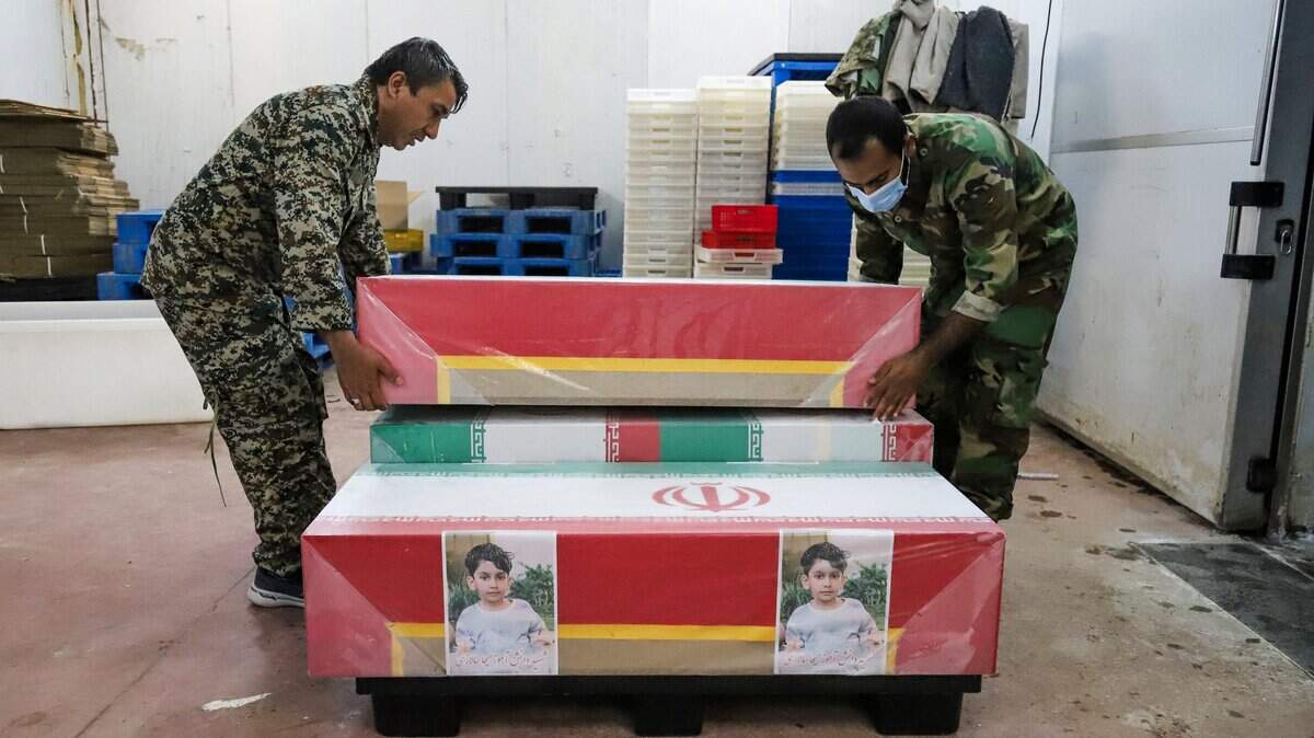 Esta imagen, obtenida de la agencia de noticias ISNA de Irán, muestra a dolientes preparando los féretros de los niños que murieron en un supuesto ataque a una escuela primaria en la provincia de Hormozgán, Irán, para un funeral en Minab el 3 de marzo de 2026.