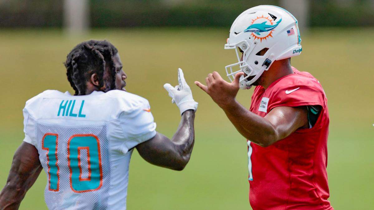 El wide receiver de los Dolphins Tyreek Hill y el quarterback Tua Tagovailoa conversan durante la práctica del equipo en el Baptist Health Training Complex en Miami Gardens, el 22 de septiembre de 2022.