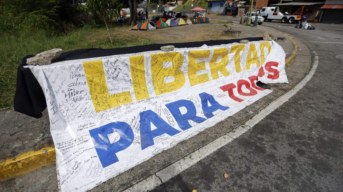 A banner reading "Freedom for all" is displayed in front of El Rodeo I prison in Guatire, Miranda state, Venezuela, on February 20, 2026. Venezuela's National Assembly on February 19 unanimously approved a long-awaited amnesty law that could free hundreds of political prisoners jailed for being government detractors. (Photo by Pedro MATTEY / AFP via Getty Images)