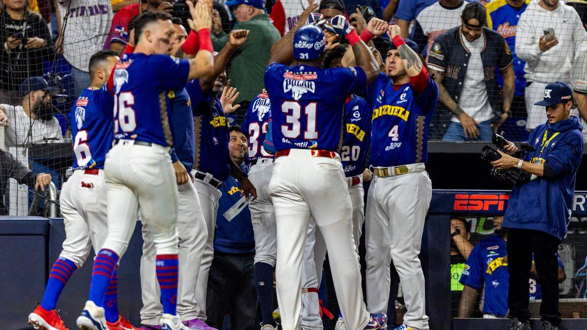 Los jugadores de Venezuela Yasiel Puig (31) y Ramón Flores (33) celebran tras anotar carreras ante Curazao, en el partido de semifinal de la Serie del Caribe, celebrado el 8 de febrero de 2024 en Miami,.