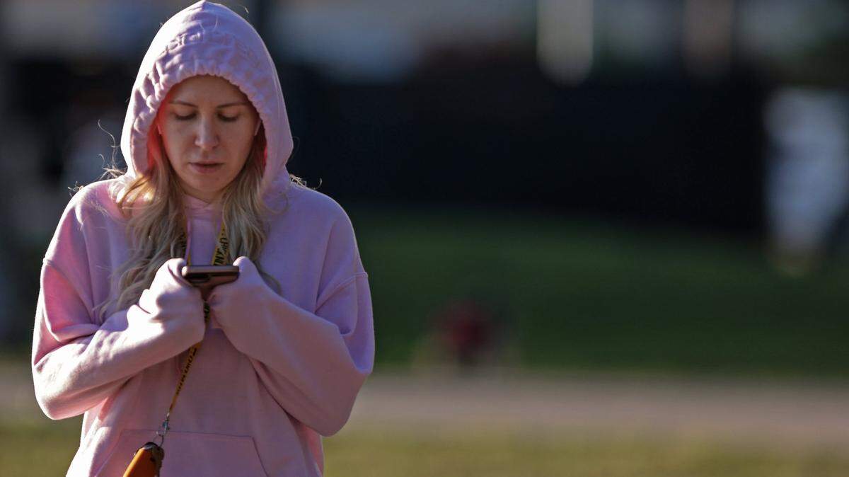 A woman, dressed for the chill, walks along the shoreline of Bayfront Park on Monday, Jan. 24, 2022. Lows are again forecast to dip into the 40s on Saturday, Jan. 29, according to the National Weather Service in Miami.