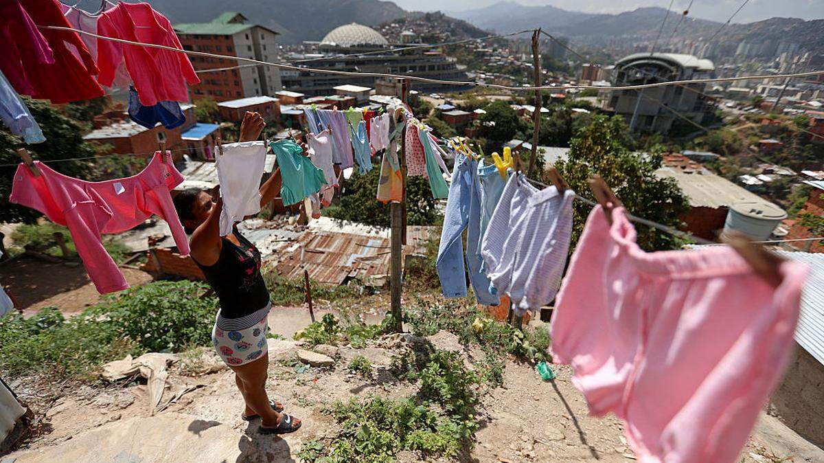 Una mujer tiende ropa a secar en los alrededores de El Helicoide (al fondo), una instalación y prisión propiedad del gobierno venezolano y que alberga tanto a presos comunes como a presos políticos del Servicio Bolivariano de Inteligencia Nacional (SEBIN), en Caracas, el 26 de febrero de 2026.