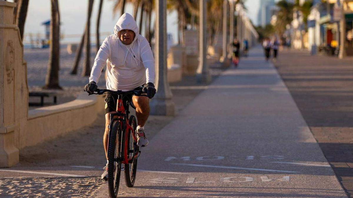 Un ciclista en Hollywood Beach abrigado en una fría mañana de primavera de 2023.