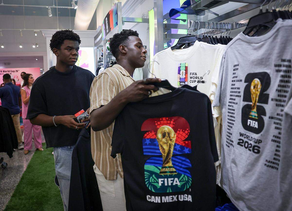 Los hermanos Gaethan y Brian Lafortune seleccionan artículos de la FIFA —con un límite de compra de 200 dólares— el lunes en Miami Beach.