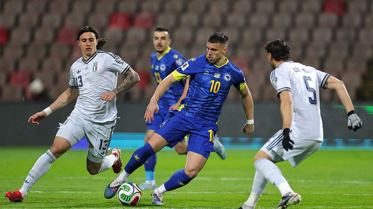 El jugador de de Bosnia y Herzegovina Ermedin Demirovic (centro) conduce el balón ante la marca Riccardo Calafiori (izq.) y Manuel Locatelli, de Italia, en el partido del repechaje europeo celebrado el 31 de marzo de 2026 en Zenica, Bosnia y Herzegovina. 