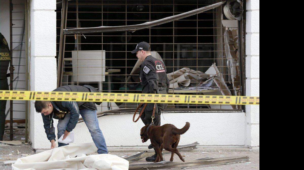 Oficiales de policía inspeccionan una oficina impactada por una explosión, el jueves 2 de julio en Bogotá, Colombia. 
