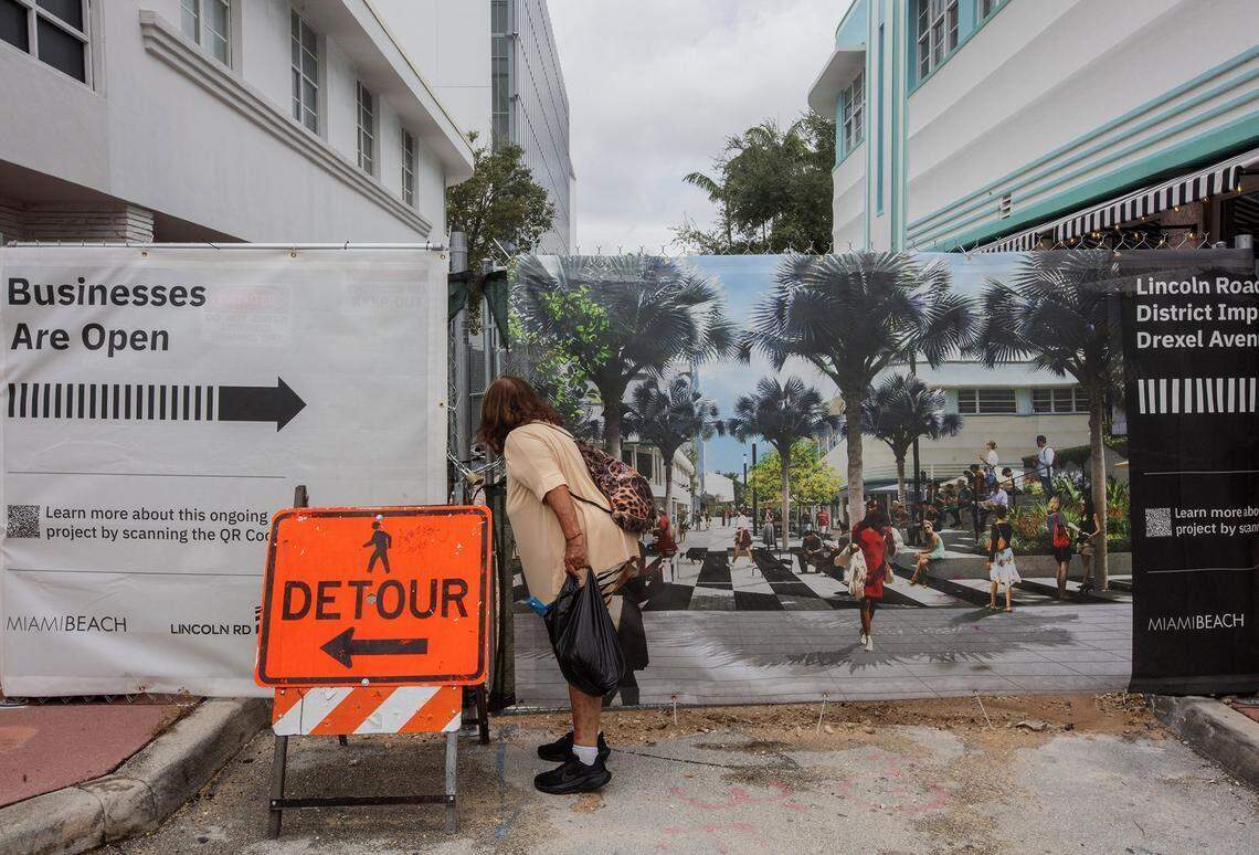 Una mujer observa a través de una reja las obras en la intersección de Lincoln Road Mall y Drexel Avenue, donde se inició la renovación de la famosa calle peatonal, que se retrasó durante mucho tiempo, a principios de septiembre.