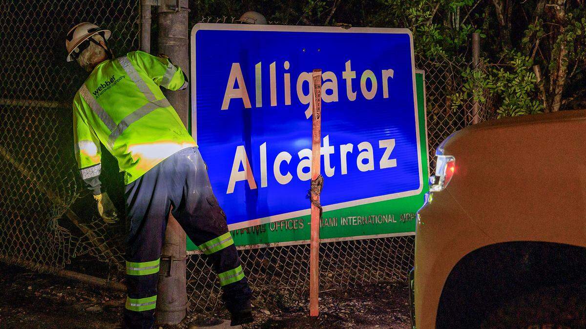 Dos trabajadores colocaron el letrero “Alligator Alcatraz”, a la entrada del centro de detención de migrantes, en Ochopee, Florida, el miércoles 02 de julio de 2025.