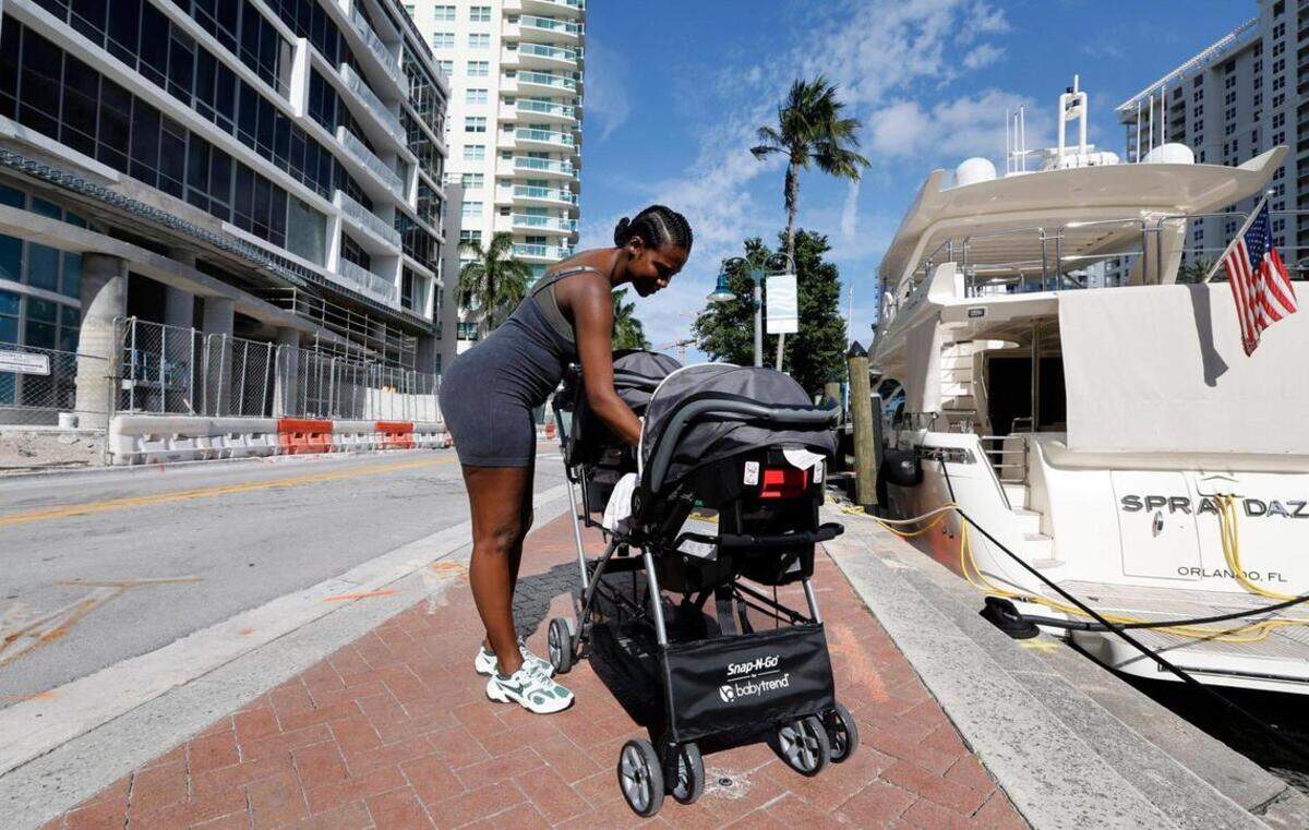 Jayme Callahan, de 40 años y residente del centro, cuida a sus gemelas, Journey y Jayme, mientras pasea por el Paseo del Río de Fort Lauderdale el jueves 24 de abril de 2025. Callahan comentó que esperaba con ansias las renovaciones del Parque Huizenga para llevar a sus hijas.