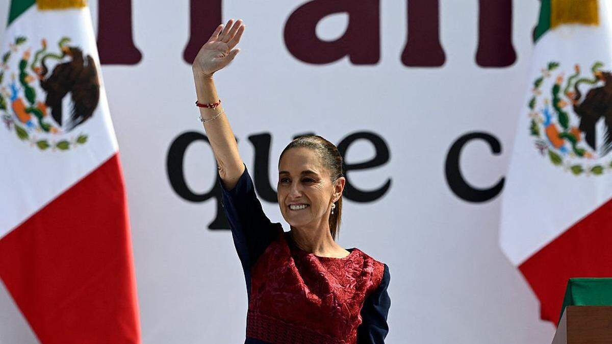Mexico's President Claudia Sheinbaum waves during a rally marking the seventh anniversary of the Morena party in government in Mexico City on December 6, 2025. Sheinbaum called for a massive rally to reaffirm her leftist government after a turbulent month marked by political violence and the abrupt resignation of the attorney general. (Photo by Alfredo ESTRELLA / AFP via Getty Images)