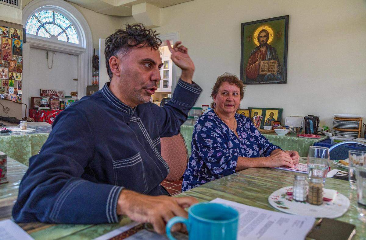 El diácono Georgios Zervos y la líder parroquial Susan Homyk hablan con periodistas en la tienda de la Iglesia Católica Griega Ortodoxa Rusa de los Santos Pedro y Pablo en La Pequeña Habana, una de las parroquias ortodoxas orientales más antiguas de Miami, ubicada en la antigua casa del primer alcalde de Miami.