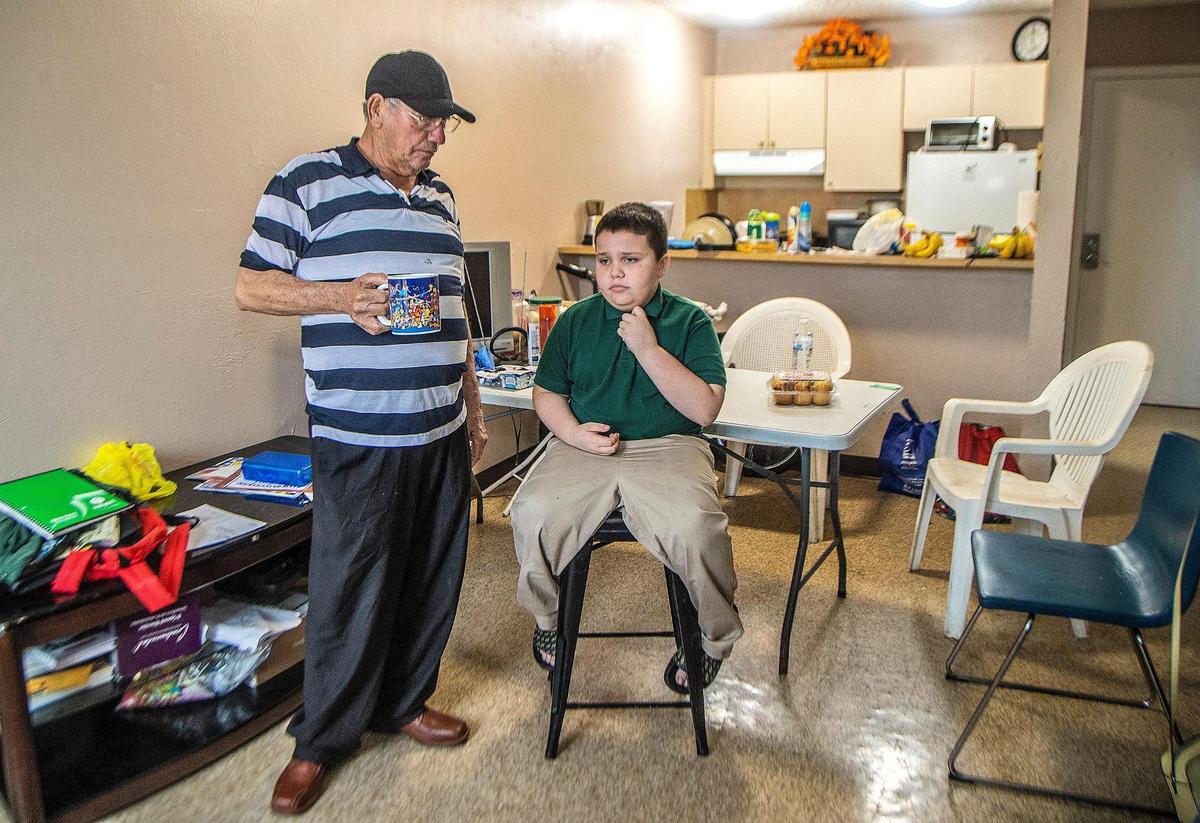Concepción Gutiérrez and his son, Iván, in the living room of their unfurnished apartment in Hialeah. They need many things for their home, but most of all, Iván needs a computer to help him in school.