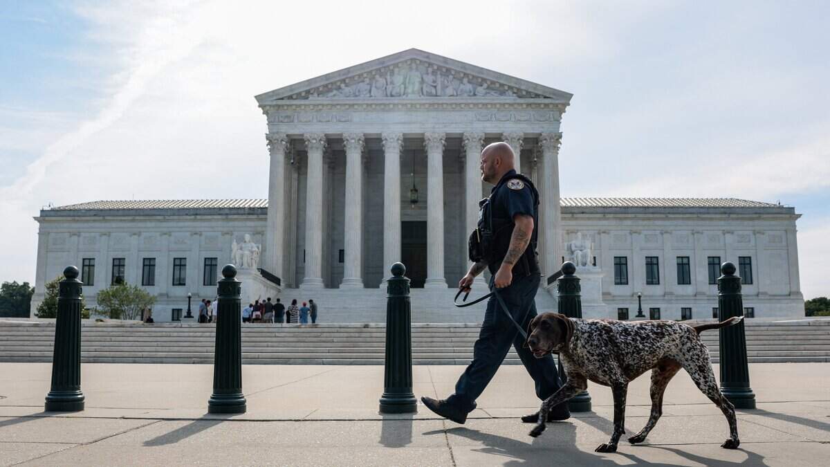 Un agente de la Policía de la Corte Suprema y su perro patrullan frente al edificio de la Corte el 22 de junio de 2026 en Washington, DC.