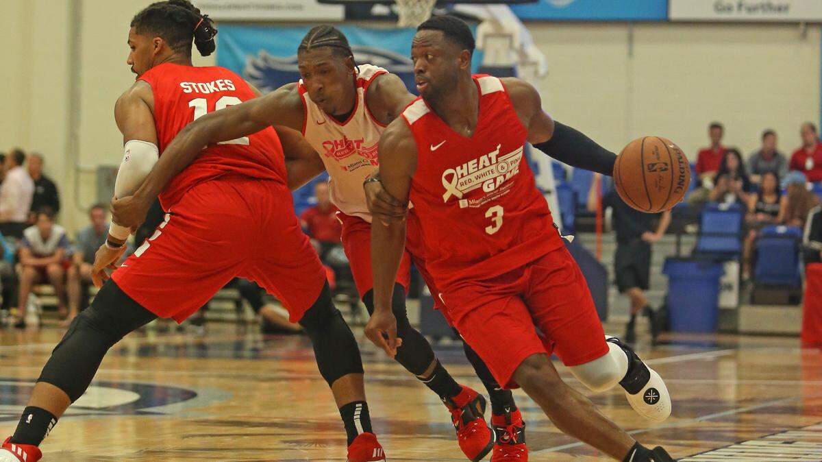 Dwyane Wade trata de escapar de la marca de Josh Richardson en el partido simulado entre Rojos, Blancos Y Rosados en la FAU Arena este sábado.