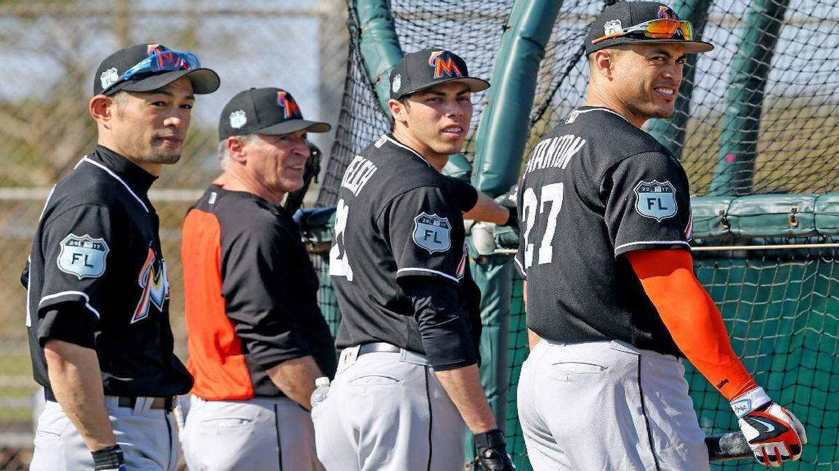 Ichiro Suzuki (izq.), Giancarlo Stanton y Christian Yelich (desde la der.) esperan para entrar a la caja de bateo, en el primer día de prácticas del equipo completo, en el campamento de entrenamientos de los Marlins, el viernes 17 de febrero del 2017.