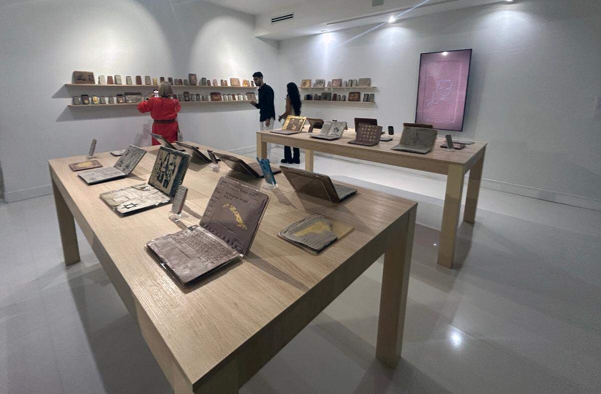 La instalación juega con la yuxtaposición de los aparatos tecnológicos que se venden en las tiendas de Apple por sus propios avatares hechos de barro, adornados con inscripciones de textos e imágenes a relieve.