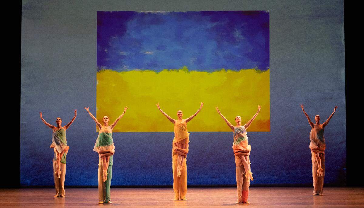 Imagen final del ballet “Pictures at an Exhibition”, coreografía de Alexei Ratmansky, con la bandera de Ucrania al fondo.
