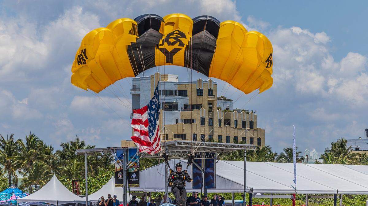 Un miembro de los Golden Knights del Ejército de los EEUU se prepara para tocar tierra en South Beach durante el Hyundai Air & Sea Show que regresa para su octavo saludo anual nacional a los Héroes de América en Miami Beach, el sábado 25 de mayo de 2024.