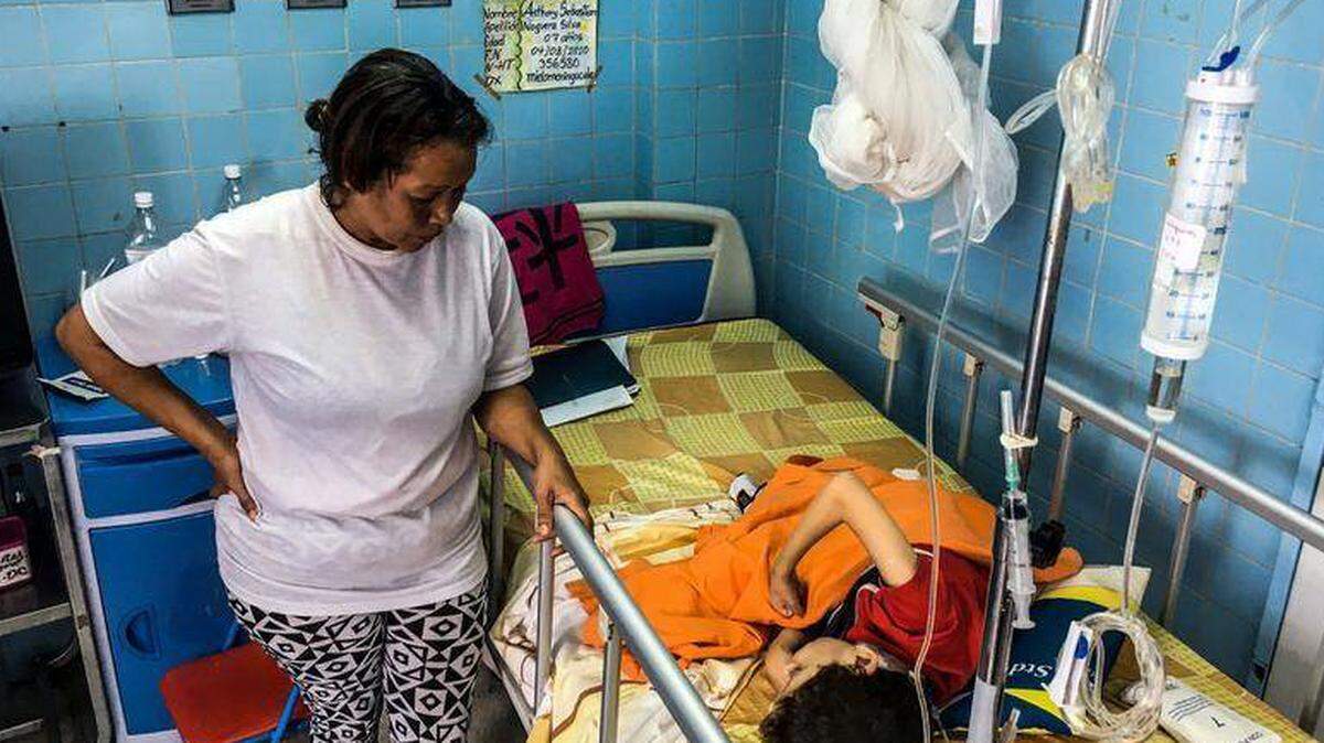 Una mujer se encuentra junto a su hijo en una sala de neurocirugía del Hospital de Niños "Dr. JM de los Ríos" en Caracas el 10 de abril de 2018.