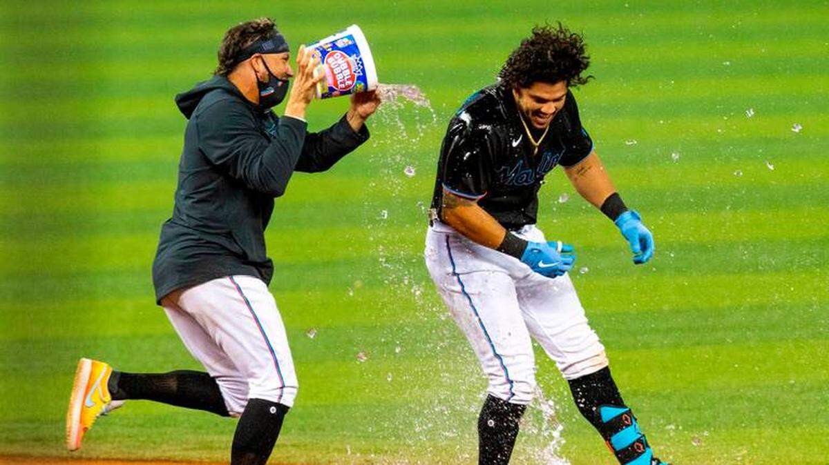 MIGUEL ROJAS arroja agua a modo de celebración sobre Jorge Alfaro tras pegar su doble decisivo contra los Gigantes.