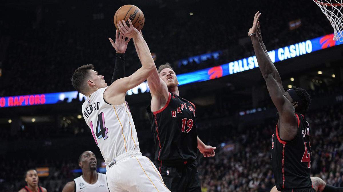 El escolta del Heat Tyler Herro (izq.) tira al aro ante la marca de Jakob Poeltl (19) y Pascal Siakam (43), de los Raptors, en el partido celebrado el 28 de marzo de 2023 en Toronto.