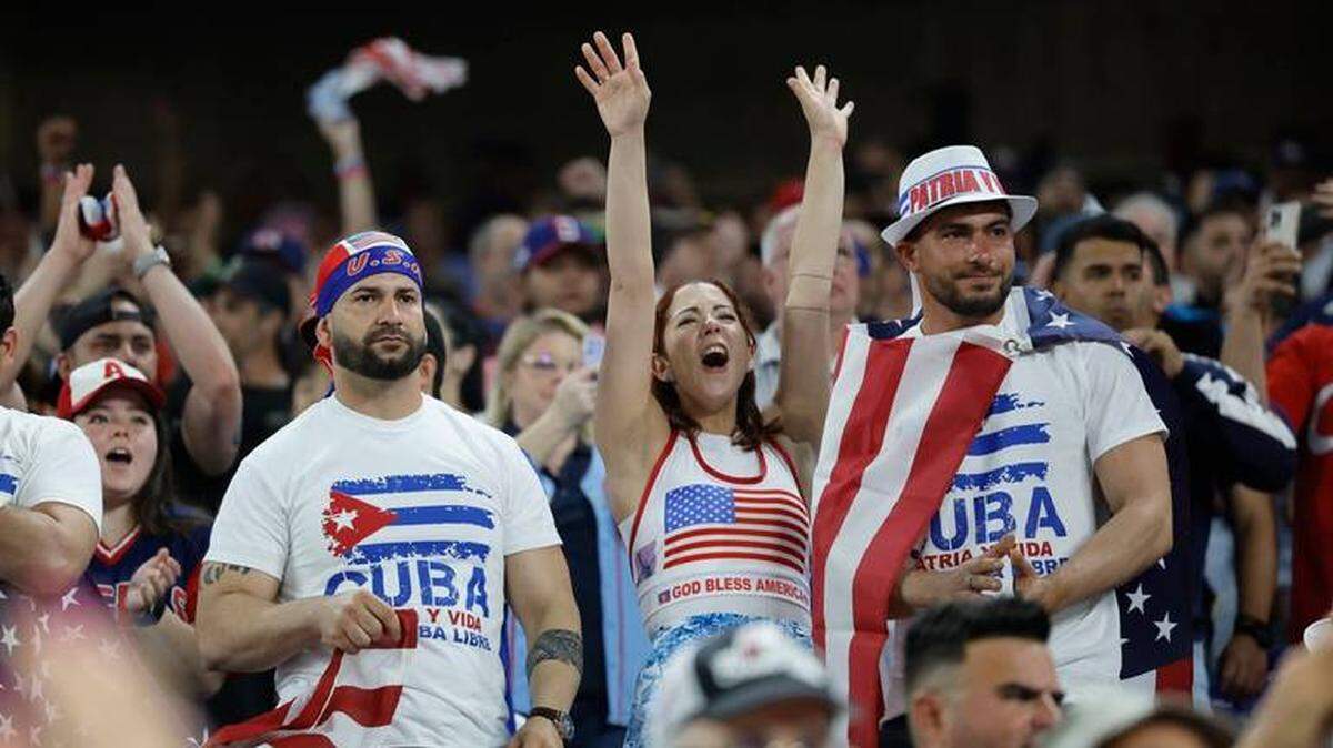 Aficionados al béisbol con camisetas de Patria y Vida asisten al partido entre Estados Unidos y Cuba durante la semifinal del Clásico Mundial de Béisbol en el loanDepot Park de Miami, Florida, el domingo 19 de marzo de 2023.