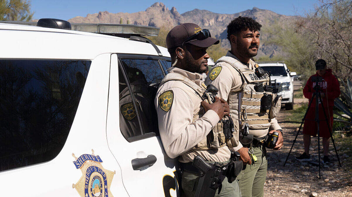 Dos agentes de la Oficina del Sheriff del Condado de Pima se encuentran frente a la casa de Nancy Guthrie, el 8 de febrero de 2026 en Tucson, Arizona.
