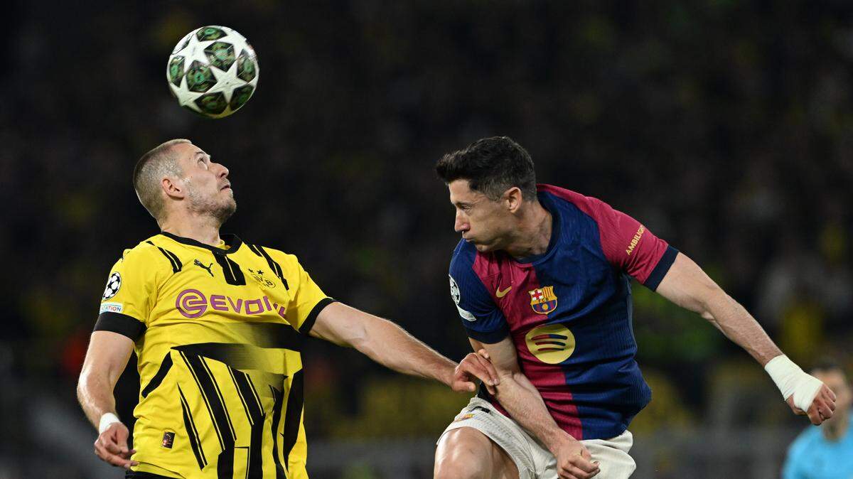 El jugador del Borussia Dortmund Waldemar Anton cabecea el balón ante la marca de Robert Lewandowski, del Barcelona, en el partido de vuelta de los cuartos de final de la Liga de Campeones celebrado el martes en Dortmund, Alemania.